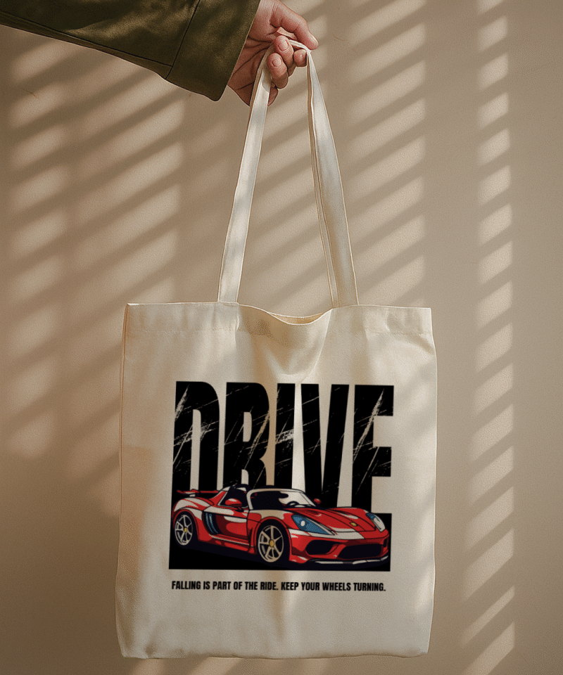 White tote bag with sporty car design and quote “Falling is part of the ride. Keep your wheels turning.”
