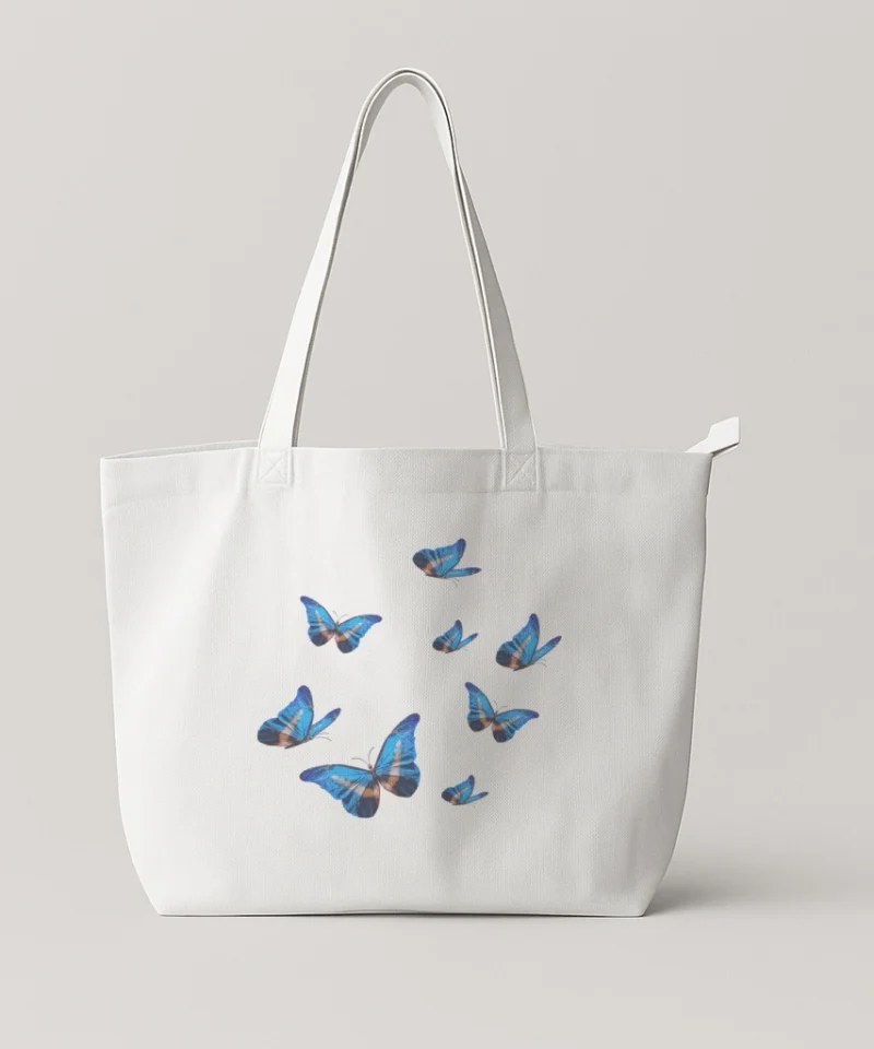 White tote bag featuring vibrant blue butterflies.