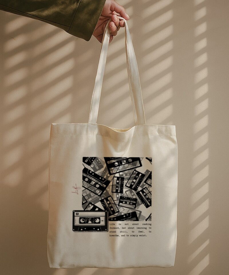 Tote bag with black-and-white cassette collage and mindful life quote.