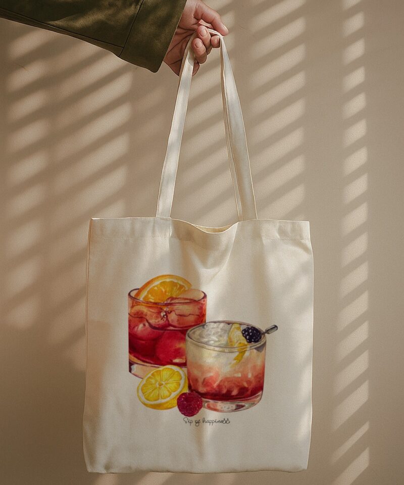 ote bag with two cocktail illustrations and text “Sip of Happiness” beneath.