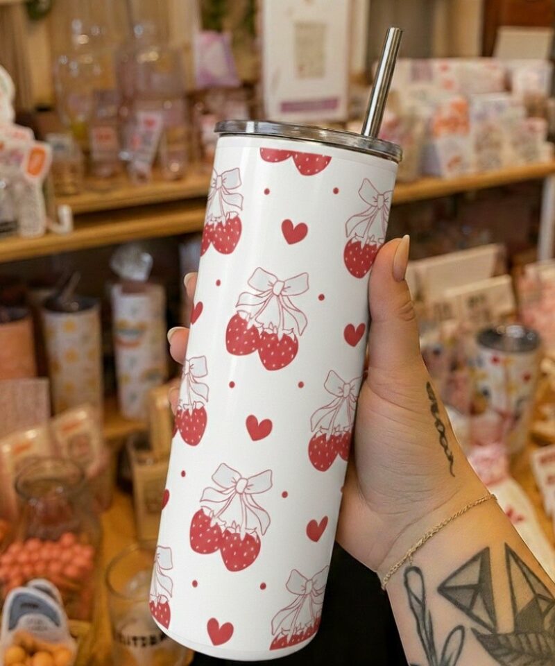 White tumbler with repeating red strawberry and bow pattern, accented with hearts and dots